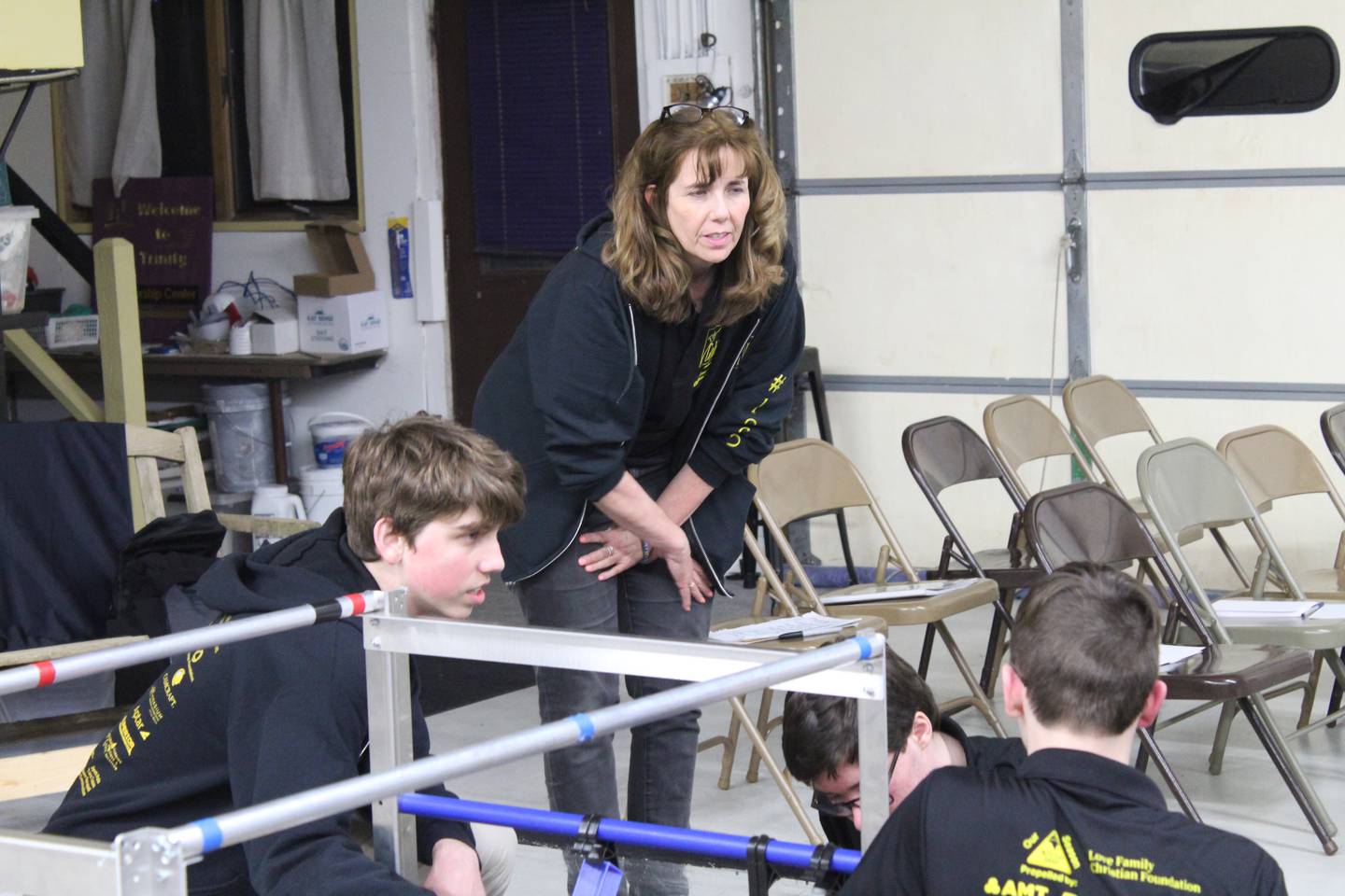 Coach of the McHenry County STEM team The Golden Ration Melissa Ryan talks with two team members before heading to the international competition in Texas.